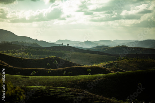 Mountainous ridges with green terrains and blue sky photo