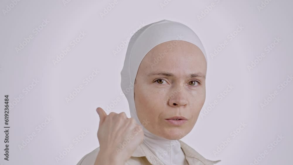 Young muslim female in head scarf counts the fingers Young muslim female in head scarf counts the fingers