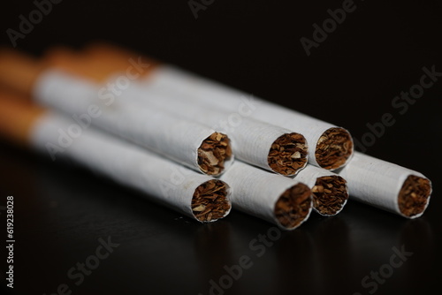 Cuadro en lienzo A view from a number of cigarettes isolated on black background tobacco close up