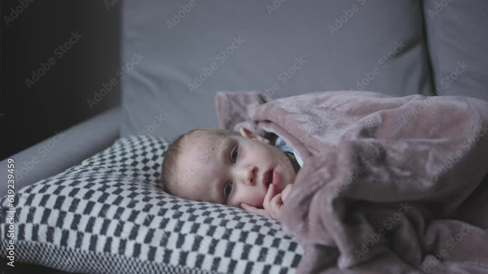 baby toddler kid suffering from chicken pox lying in bed covered