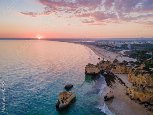 Aerial dusk view of Praia dos Tres Irmaos (Three Brothers beach) in Alvor, famous tourist destination in Western Algarve Coast, Portugal.