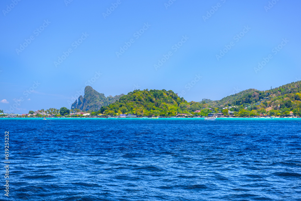 Naklejka premium Motor ship in the bay of Ko Phi Phi Don Island with huge rocks and cliffs on a sunny day, Ao Nang, Mueang Krabi District, Krabi, Andaman Sea, Thailand