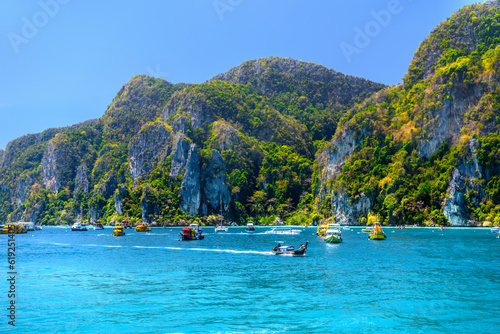Boats and ships in the bay of Ko Phi Phi Don Island with huge rocks and cliffs on a sunny day, Ao Nang, Mueang Krabi District, Krabi, Andaman Sea, Thailand