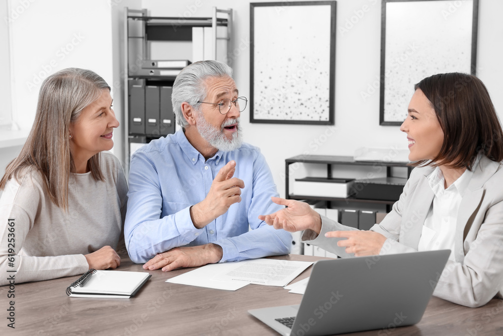 Elderly couple consulting insurance agent about pension plan at wooden table indoors Elderly couple consulting insurance agent about pension plan at wooden table indoors