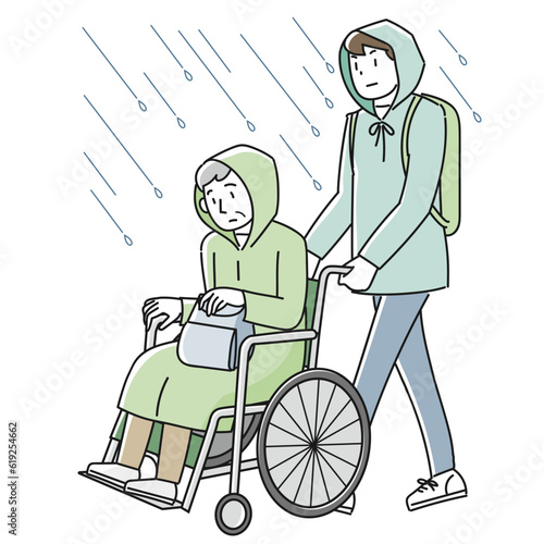 雨の中を避難する車椅子に乗った高齢男性と支援する男性