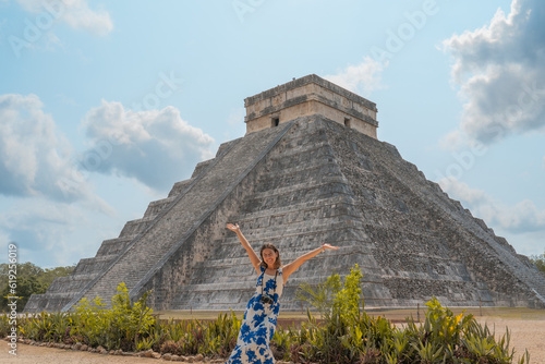 young woman visits one of the most beautiful pyramids in the world, the pyramid of chichen itza in mexico with her camera photo