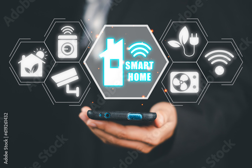 Smart home automation control system, Man hand using smart phone with smart home control icon on VR screen, Innovation technology internet network concept.