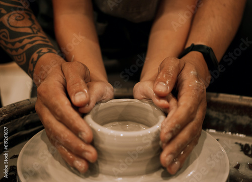 Hands close up. Father and child boy. Mold ceramic vase in a pottery workshop.