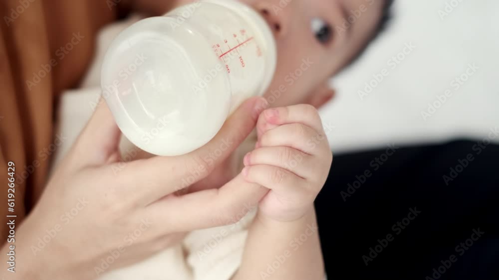 4K Slow Motion, Embracing Love and Nourishment as Asian Baby’s Hand Touches Mother’s Hand During Milk Feeding from Milk Bottle, Conveying the Beauty of Maternal Bond and Baby Care. 4K Slow Motion, Embracing Love and Nourishment as Asian Baby’s Hand Touches Mother’s Hand During Milk Feeding from Milk Bottle, Conveying the Beauty of Maternal Bond and Baby Care.