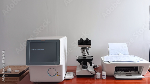 Workspace for health and medical professionals equipped with hematology tools, microscopes and printing equipment