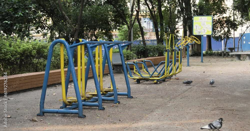 Outdoor gym equipment unused due to pandemic, pigeons walking nearby. Static Outdoor gym equipment unused due to pandemic, pigeons walking nearby. Static