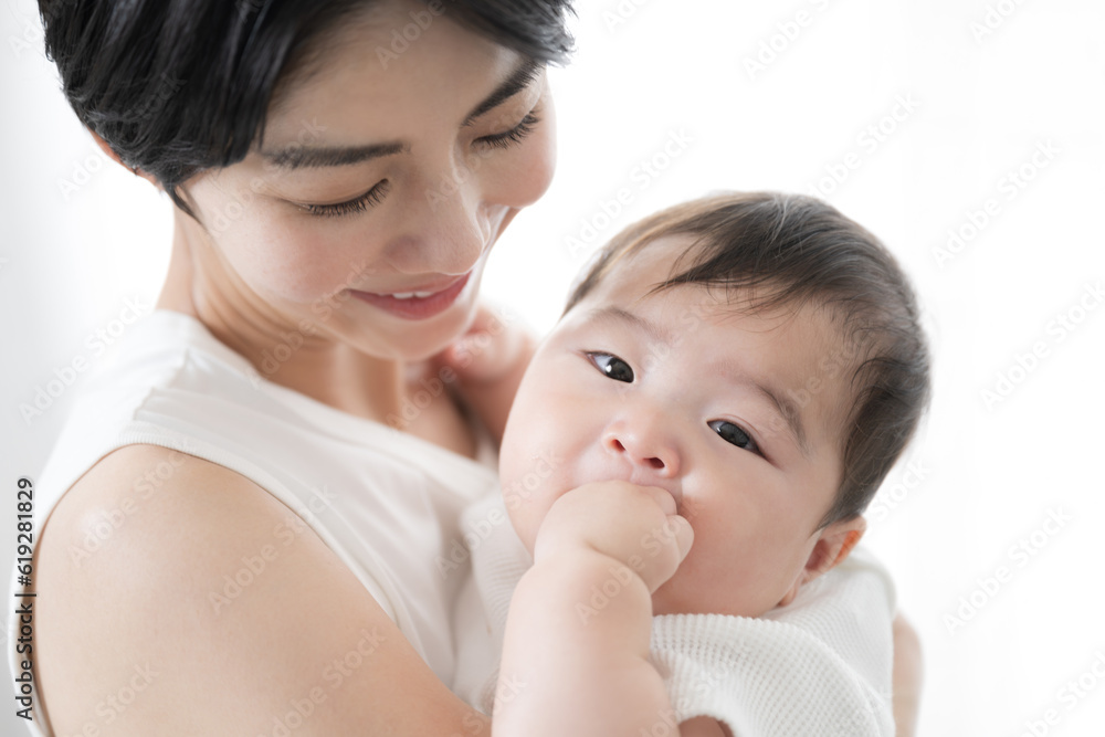 Lovely Asian (Japanese) mother holding her baby Close-up looking at the camera Lovely Asian (Japanese) mother holding her baby Close-up looking at the camera