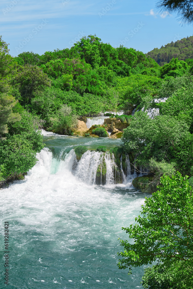Fototapeta premium Beautiful Waterfall background in sunny summer day. Beautiful Waterfall In Krka National Park - Croatia, Europe. Krka river waterfalls in the Krka National Park
