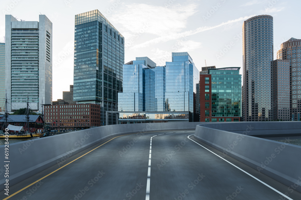 Empty urban asphalt road exterior with city buildings background. New modern highway concrete construction. Concept of way to success. Transportation logistic industry fast delivery. Boston. USA. Empty urban asphalt road exterior with city buildings background. New modern highway concrete construction. Concept of way to success. Transportation logistic industry fast delivery. Boston. USA.