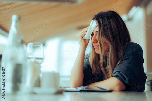 Woman Wiping Sweaty Forehead Using a Napkin. Lady suffering from hot flashes due to early menopause symptoms
 photo