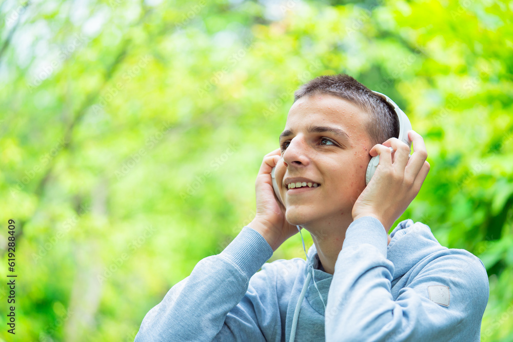 Portrait of a teenager with headphones outdoors,teenager listens to music Portrait of a teenager with headphones outdoors,teenager listens to music