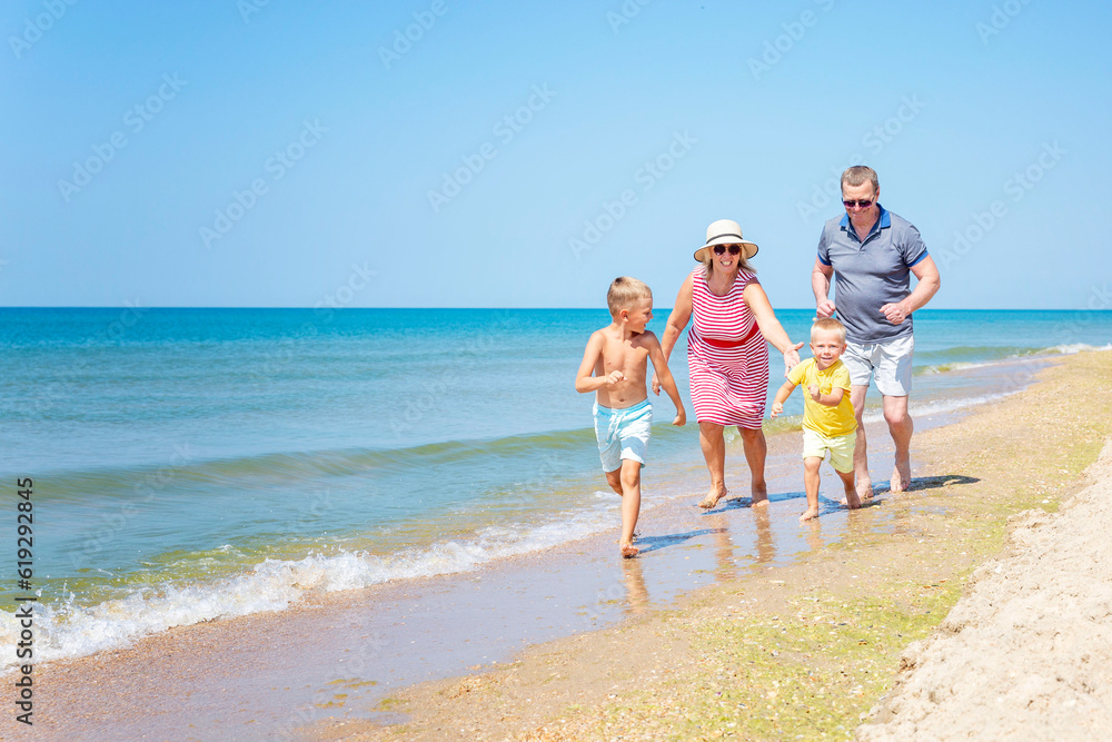 Elderly people play with children on the seashore on a sunny day. Love and tenderness. Active lifestyle and family relationships.