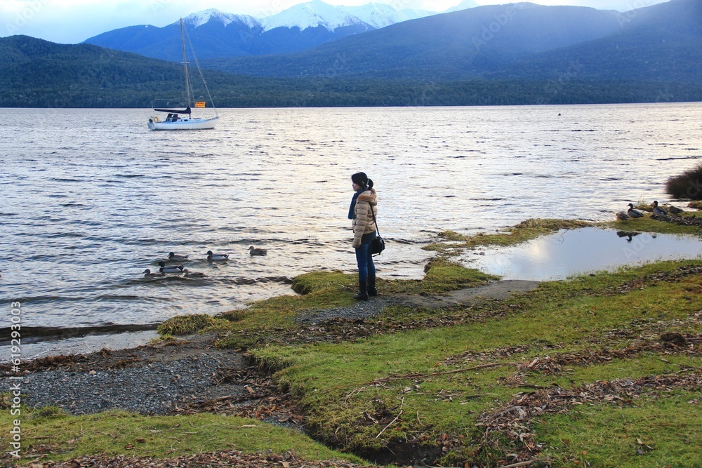 Tourist playing and enjoying beautiful Te Anau lake.
