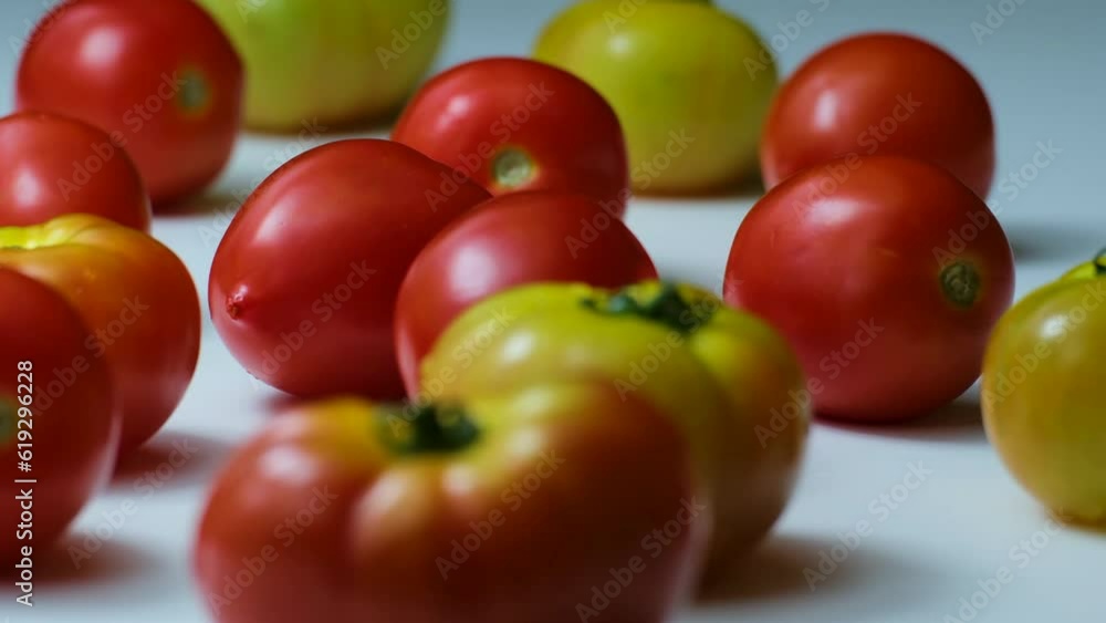 Variety of Red and Yellow Tomatoes Placed on a White Surface. Slow Dolly Upwards Shot  (UHD)
