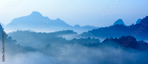 Landscape of cool tone color mountains range at sunrise with morning fog for mountain background.