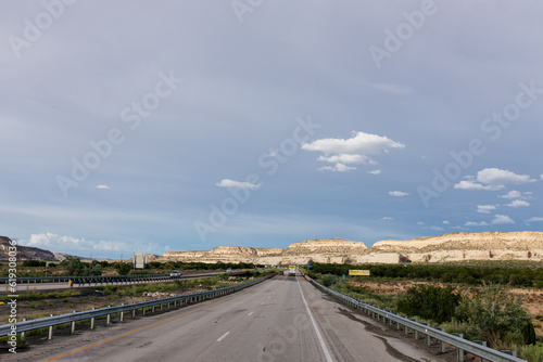 Beautiful highway in New Mexico, USA. Picturesque landscape with a road among mountains and dark blue sky on a sunny summer day. New Mexico, USA - 06-17-2023