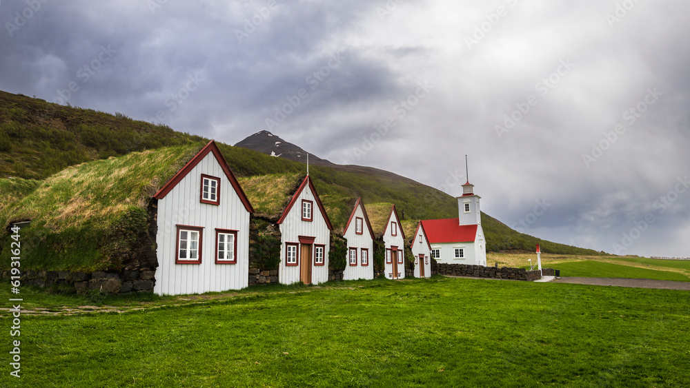 Traditional turf farm in Laufas, iceland with barn and church in summer Traditional turf farm in Laufas, iceland with barn and church in summer