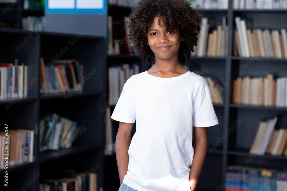 African american schoolboy wearing white t shirt with copyspace over library African american schoolboy wearing white t shirt with copyspace over library