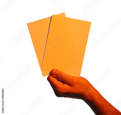 Man holding orange flyers on white background, closeup. Mockup for design