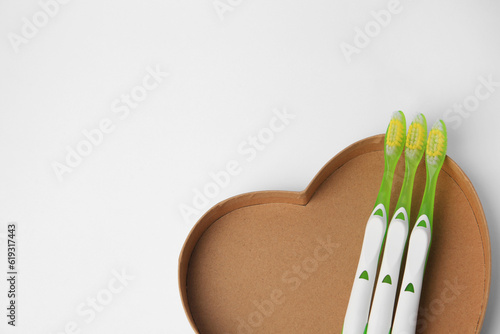 Light green toothbrushes on white background  above view. Space for text