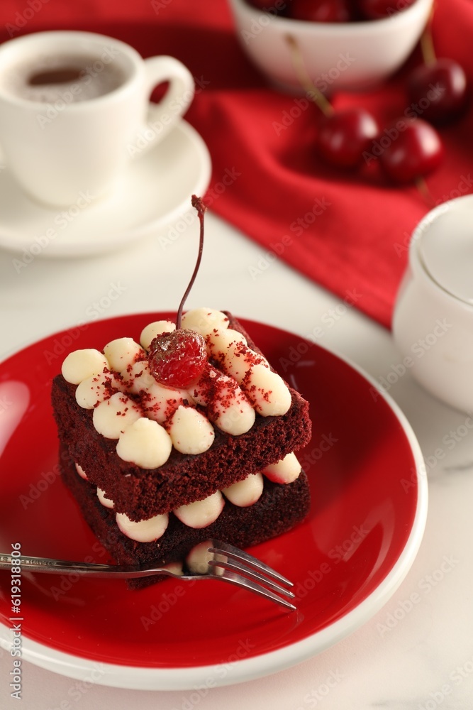 Piece of delicious red velvet cake and fork on white table, closeup Piece of delicious red velvet cake and fork on white table, closeup