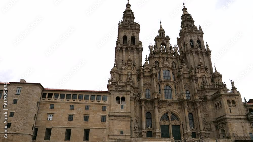 Panning shot of famous Santiago de Compostela Cathedral against cloudy sky - Ancient historical pilgrim church in Spain - bottom up Panning shot of famous Santiago de Compostela Cathedral against cloudy sky - Ancient historical pilgrim church in Spain - bottom up