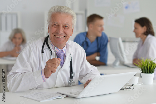 Male doctor sitting at table in clinic