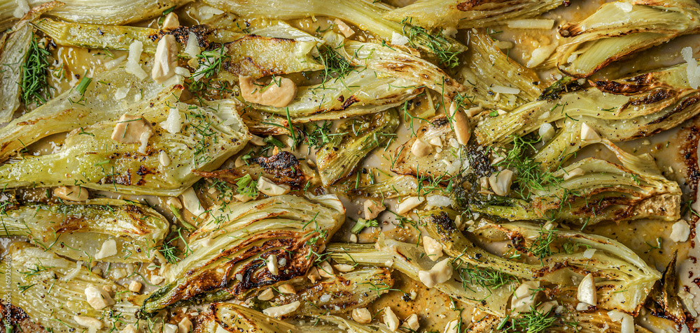 Delicious roasted fennel background with nuts and herbs, top view