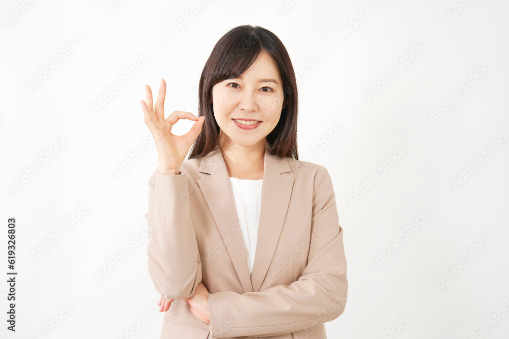 OKサインをするミドルエイジのビジネスウーマン　白背景