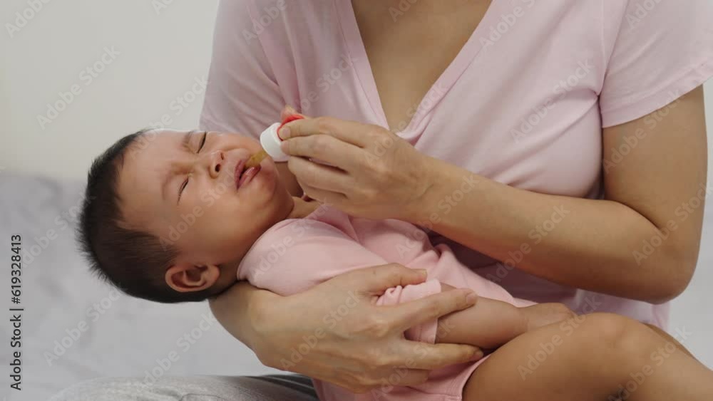 sick infant baby crying while refuses eating liquid medicine with a dropper sick infant baby crying while refuses eating liquid medicine with a dropper