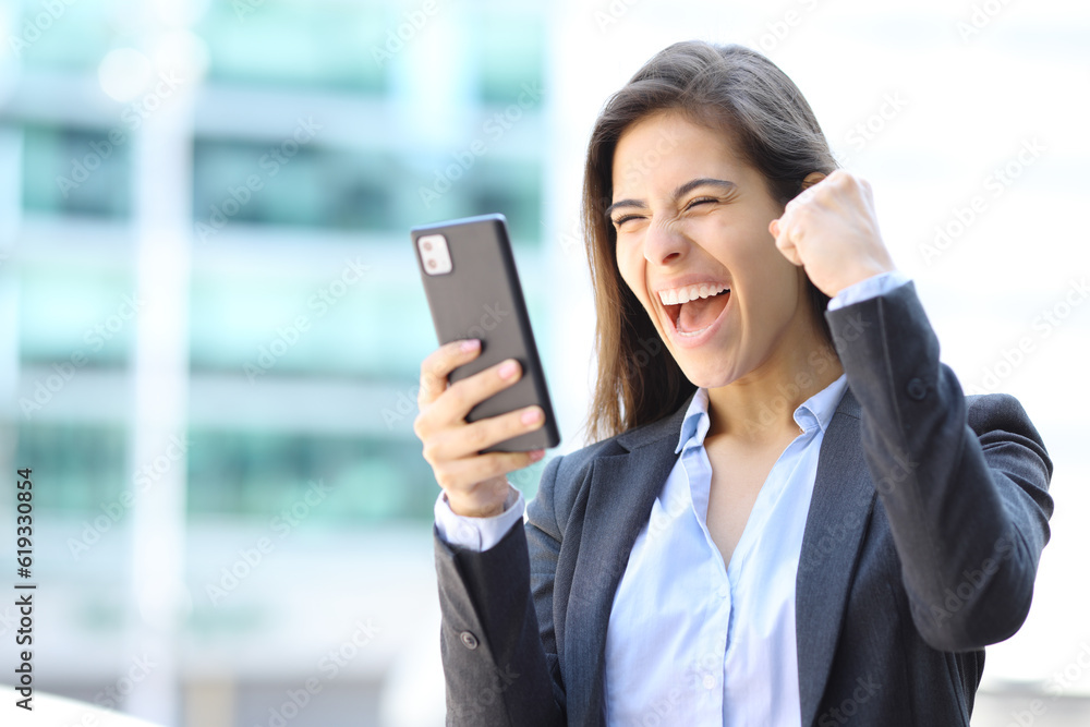 Excited executive celebrating checking cell phone Excited executive celebrating checking cell phone