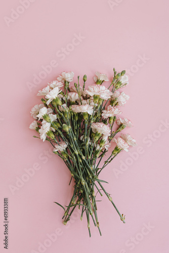 Beautiful pink carnation flowers bouquet on pink background. Elegant flat lay  top view floral composition with copy space