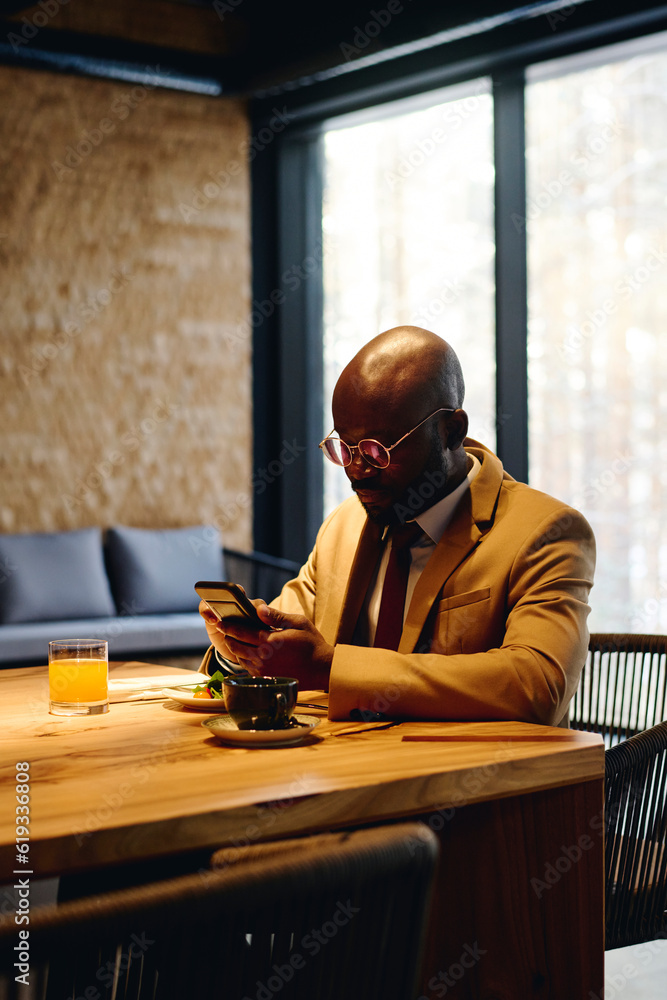 Businessman using smart phone and having lunch at conference table Businessman using smart phone and having lunch at conference table