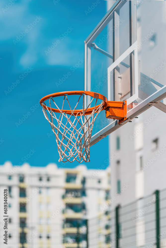 Transparent plexiglass basketball backboard with hoops on outdoor court for streetball in urban residential district