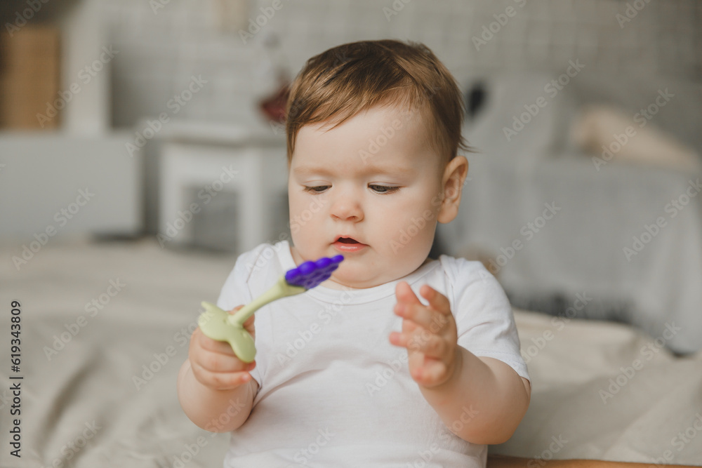 Portrait of a 7-9 month old baby in a home interior. A curious, smiling child explores the world around him. A cute baby is sitting on the floor. Portrait of a 7-9 month old baby in a home interior. A curious, smiling child explores the world around him. A cute baby is sitting on the floor.