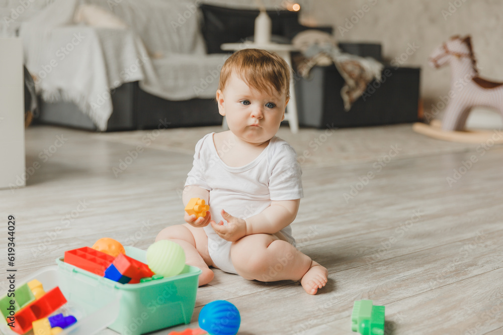 baby 6-9 months old playing with a colorful rainbow toy pyramid sitting in a white sunny bedroom. Toys for small children. Children's interior. A child with an educational toy. baby 6-9 months old playing with a colorful rainbow toy pyramid sitting in a white sunny bedroom. Toys for small children. Children's interior. A child with an educational toy.