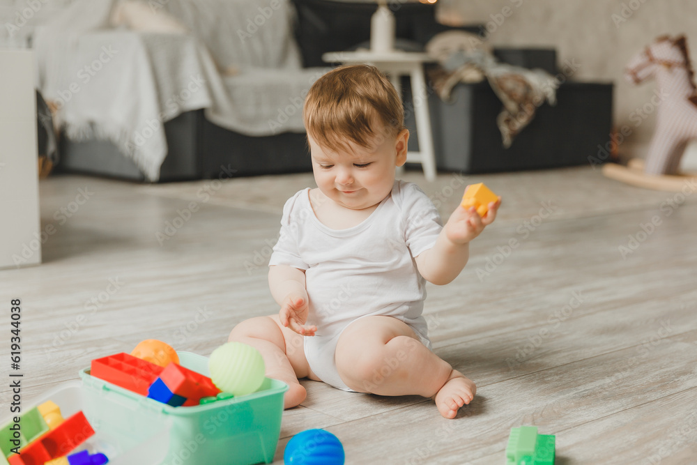 baby 6-9 months old playing with a colorful rainbow toy pyramid sitting in a white sunny bedroom. Toys for small children. Children's interior. A child with an educational toy. baby 6-9 months old playing with a colorful rainbow toy pyramid sitting in a white sunny bedroom. Toys for small children. Children's interior. A child with an educational toy.