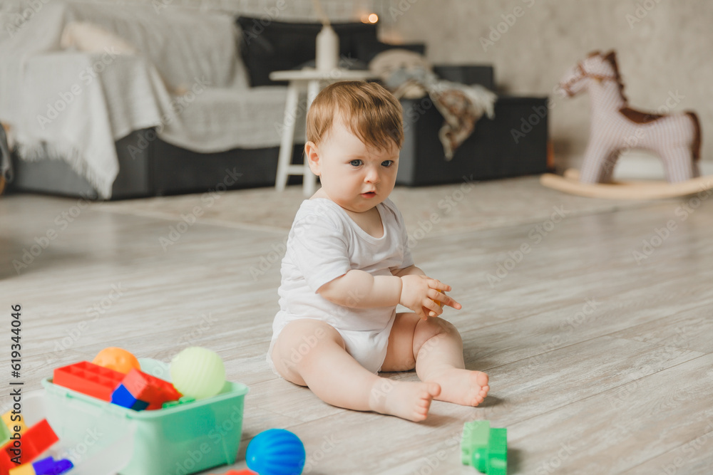 baby 6-9 months old playing with a colorful rainbow toy pyramid sitting in a white sunny bedroom. Toys for small children. Children's interior. A child with an educational toy. baby 6-9 months old playing with a colorful rainbow toy pyramid sitting in a white sunny bedroom. Toys for small children. Children's interior. A child with an educational toy.