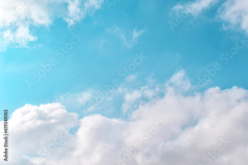 Blue pastel sky with white fluffy clouds. Summer tropical season holiday sky. Sunny day background. Copy space.
