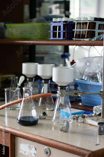 Laboratory glassware with green liquid in a science research laboratory.