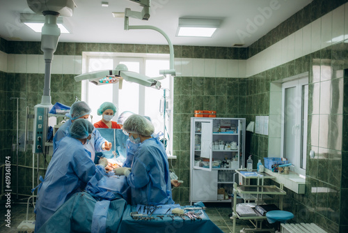 A surgeon sews up a patient in the operating room