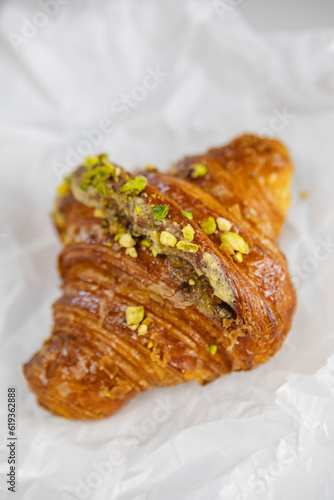 A mouth-watering croissant with a pistachio garnish in close-up
