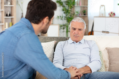 young man talking to sad elder father