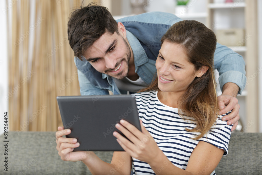 couple lying down watches video on digital tablet couple lying down watches video on digital tablet