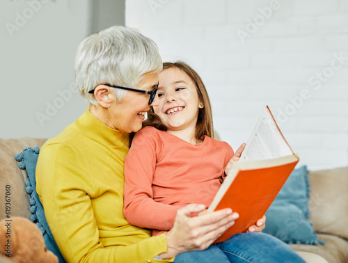 grandchild family child grandparent grandmother book reading elderly granddaughter girl  happy together read learning education woman